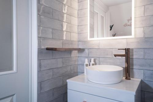 y baño con lavabo blanco y espejo. en Loughrigg at Lipwood - Stunning 2 Bedroom - 1 Bathroom - Gentleman's Residence - Central Windermere, en Windermere