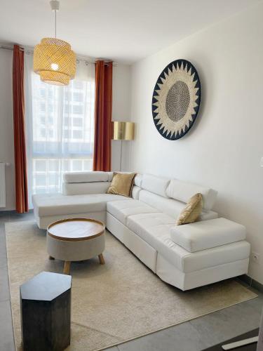uma sala de estar com um sofá branco e uma mesa em Rare ***Centre ville * Parking em Montpellier