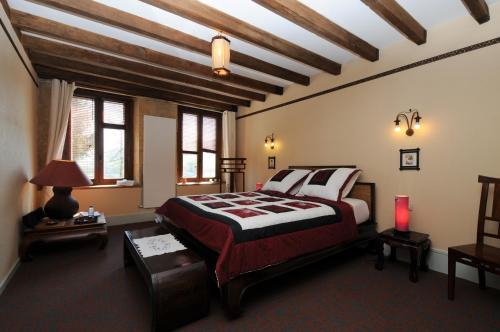 a bedroom with a bed in a room with wooden ceilings at Au Clos d'Ardennes in Balaives-et-Butz