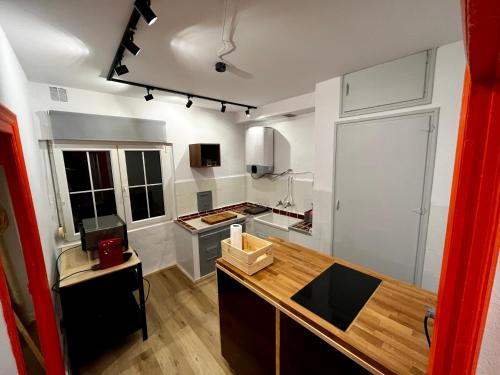 - une cuisine avec des murs blancs et un comptoir en bois dans l'établissement Loft Villaviciosa, à Villaviciosa