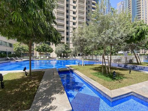 an empty swimming pool with trees and buildings at Silkhaus full Burj Khalifa & Fountains view in Downtown in Dubai
