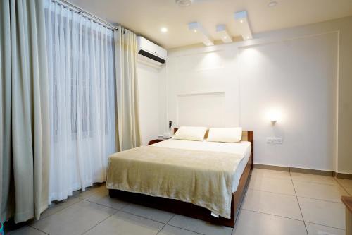 a bedroom with a bed and a large window at Kadampanattu's Homestay in Ernakulam