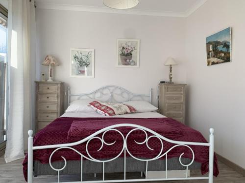 - une chambre avec un lit blanc et un couvre-lit violet dans l'établissement Bel appartement T2 avec parking et Wi-Fi à Arcachon - FR-1-374-170, à Arcachon