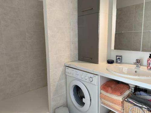 une salle de bain avec une machine à laver et un lavabo dans l'établissement Bel appartement T2 avec parking et Wi-Fi à Arcachon - FR-1-374-170, à Arcachon