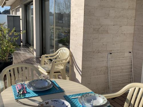 Une table à manger et des chaises sont disponibles sur la terrasse. dans l'établissement Bel appartement T2 avec parking et Wi-Fi à Arcachon - FR-1-374-170, à Arcachon