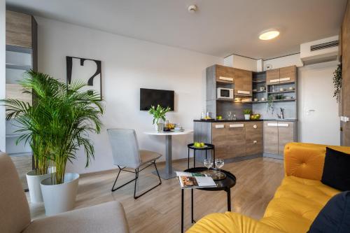 a living room with a yellow couch and a table at Starter 24 Wrocław in Wrocław