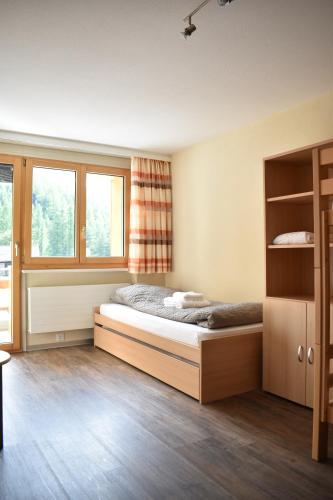 um quarto com uma cama e duas janelas em Restaurant & Hostel Hole in One em Randa