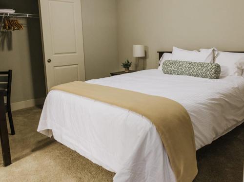 een slaapkamer met een groot bed met witte lakens en kussens bij Free parking Gym & Pool Downtown at CityWay in Indianapolis