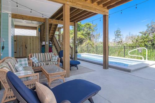 a patio with chairs and a swimming pool at Sandy Noses in Oak Island