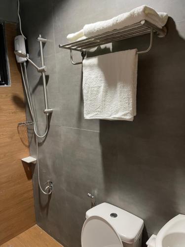 a bathroom with a toilet and a sink and towels at 1 bedroom Apartment (Industrial Loft) in Angeles