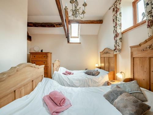 a bedroom with two beds and two windows at The Granary in Bream