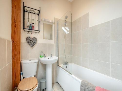 a bathroom with a toilet and a sink and a bath tub at The Granary in Bream