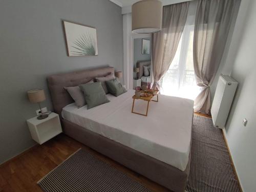 a bedroom with a large bed and a window at Haris modern apt. near the sea in Thessaloniki