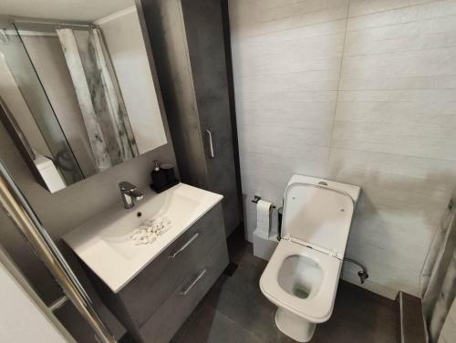 a bathroom with a white toilet and a sink at Haris modern apt. near the sea in Thessaloniki