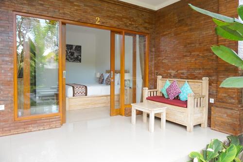 a room with a patio with a bed and a chair at Villa Semujan Ubud in Ubud