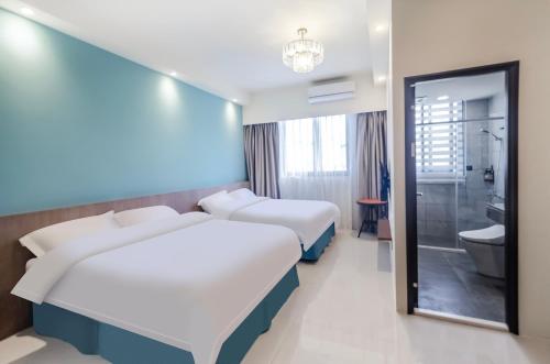 Habitación de hotel con 2 camas y baño en 春雨漫居 Spring Rain Hostel, en Meishan