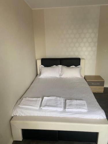 un lit avec des draps blancs et des oreillers dans une chambre dans l'établissement Appartement 2, à Les Minières