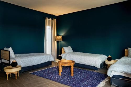 a bedroom with two beds and a blue wall at Dar Meha in Marrakech