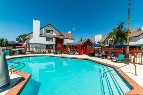 a large swimming pool with chairs and a house at Metro PHX STUDIO QUEEN sleeps 4 HEATED POOL in Phoenix