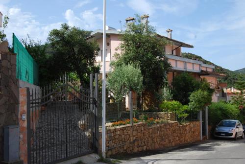 una valla frente a una casa con un edificio en Tanca is Torus, en Teulada