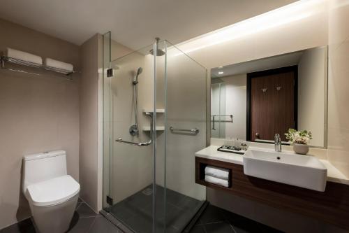 y baño con aseo, lavabo y ducha. en Oakwood Hotel and Residence Kuala Lumpur, en Kuala Lumpur