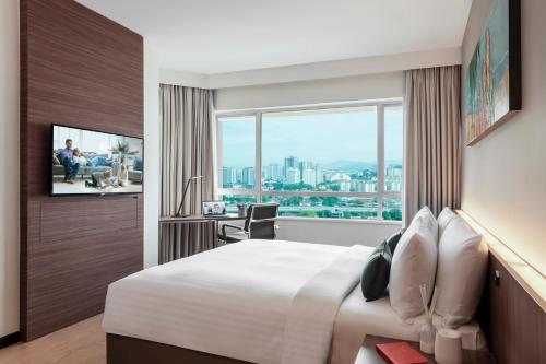 a hotel room with a bed and a window at Oakwood Hotel & Residence Kuala Lumpur in Kuala Lumpur