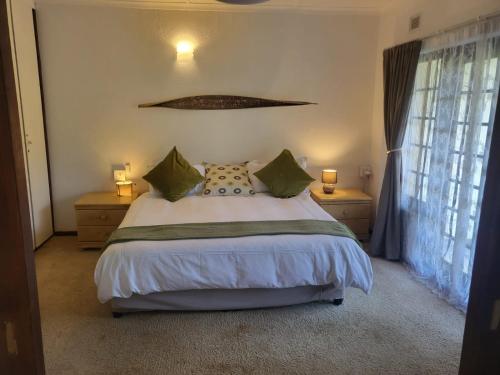 a bedroom with a bed with two night stands and two lamps at Eden Wilds 38 in Port Edward