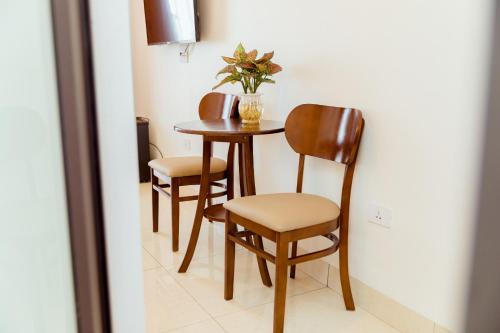 einem Tisch mit zwei Stühlen und einem Tisch mit einer Pflanze darauf in der Unterkunft Vĩnh Sơn Nội Bài in Hanoi