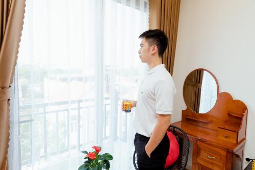 a man standing in a room looking out the window at Vĩnh Sơn Nội Bài in Hanoi