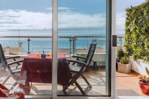 a table and chairs on a balcony with a view of the ocean at Studio L - Ericeira in Ericeira