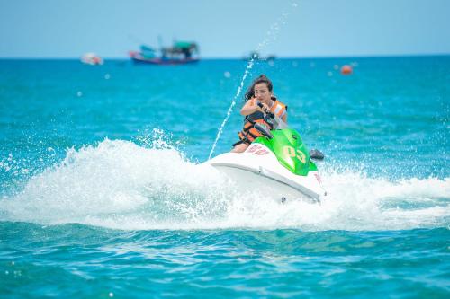 a young boy riding a jet ski in the water at FLC Luxury Resort Quy Nhon in Quy Nhon