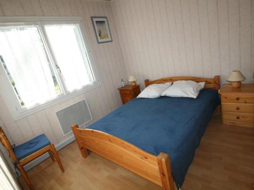 - une chambre avec un lit avec une couverture bleue et 2 fenêtres dans l'établissement Villa indépendante avec jardin clos, proche plage et commerces - FR-1-22-303, à Longeville-sur-Mer