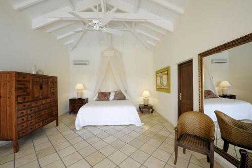 a bedroom with two beds and a ceiling fan at 5 bedrooms villa at Saint Martin 200 m away from the beach with sea view private pool and furnished garden in Saint Martin