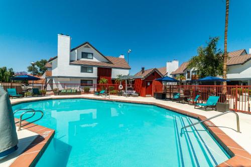 a large swimming pool with chairs and a house at Metro PHX Upstairs 2bd sleeps 6 heated pool NO PETS ALLOWED in Phoenix