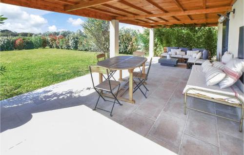 a patio with a table and chairs under a wooden roof at Stunning Home In Pernes-Les-Fontaines in Pernes-les-Fontaines