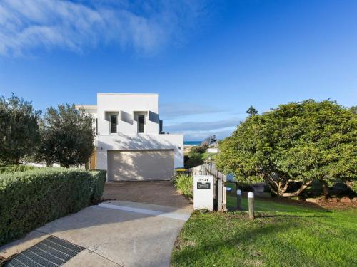 a white house with a driveway at Mazza by the Sea - Beachside Family Escape in Lake Tyers
