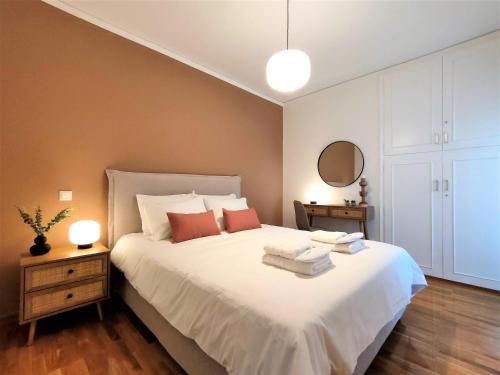 a bedroom with a large white bed with red pillows at Vouliagmeni Iasonos Residence Central Stylish Flat in Athens
