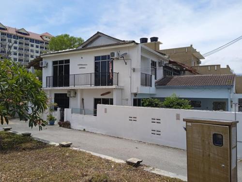 a white house with a fence in front of it at My Beach Villa in Port Dickson