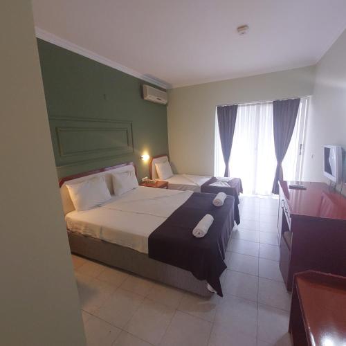 a hotel room with two beds and a window at PİGALE BEACH RESORT in Kuşadası