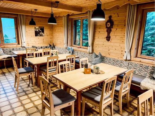 ギンツリングにあるGrawandhütteの木製のテーブルと椅子、窓のあるレストラン