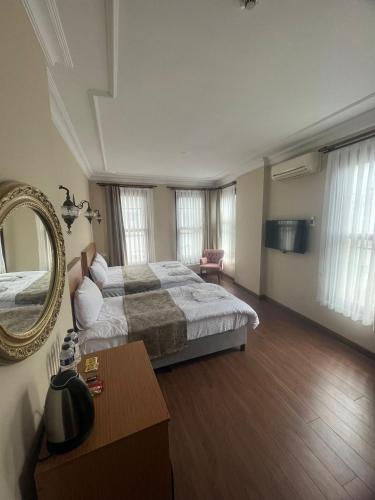 una grande camera da letto con un letto grande e uno specchio di Ottoman Elegance Hotel a Istanbul