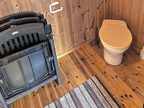 a wooden bathroom with a toilet and a tv at Two-Bedroom Holiday home in Farsund 1 in Helle