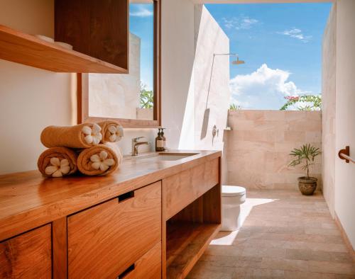 baño con lavabo y aseo y ventana en Sumberkima Resort en Pemuteran
