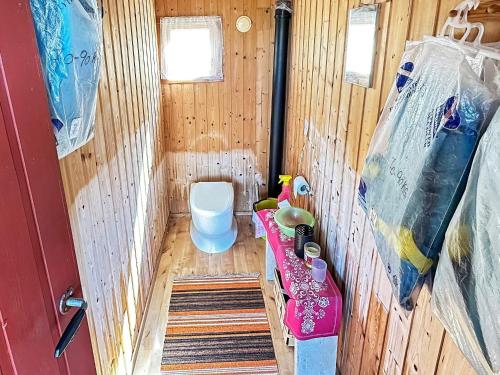 een kleine badkamer met een toilet in een houten cabine bij Two-Bedroom Holiday home in Farsund 4 in Helle