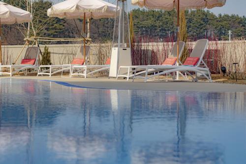 a group of chairs and umbrellas next to a swimming pool at Corallo By Josun in Yangyang