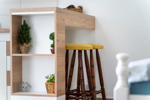 a shelf with stools in a room with plants at Apartments Gruda in Cetinje