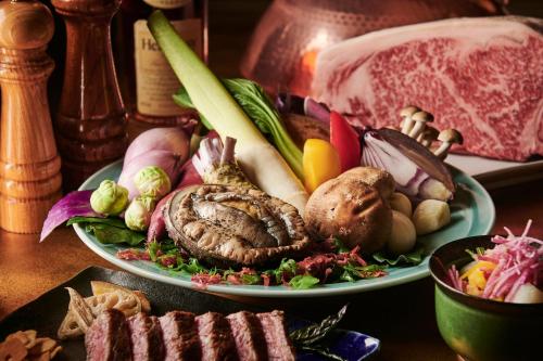 two plates of food with meat and vegetables on a table at ANA Crowne Plaza Kanazawa by IHG in Kanazawa