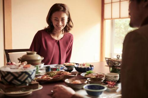 a woman standing in front of a table full of food at ANA Crowne Plaza Kanazawa by IHG in Kanazawa