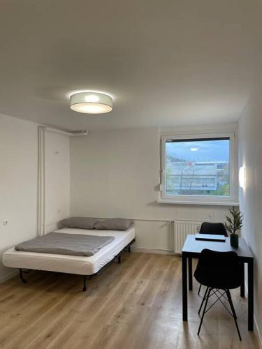 Schlafzimmer mit einem Bett, einem Tisch und einem Fenster in der Unterkunft Renewed one bedroom apartment on a good location in Ljubljana