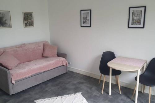 a living room with a couch and a table and chairs at Le Calme - Appartement 2 pièces in Alfortville